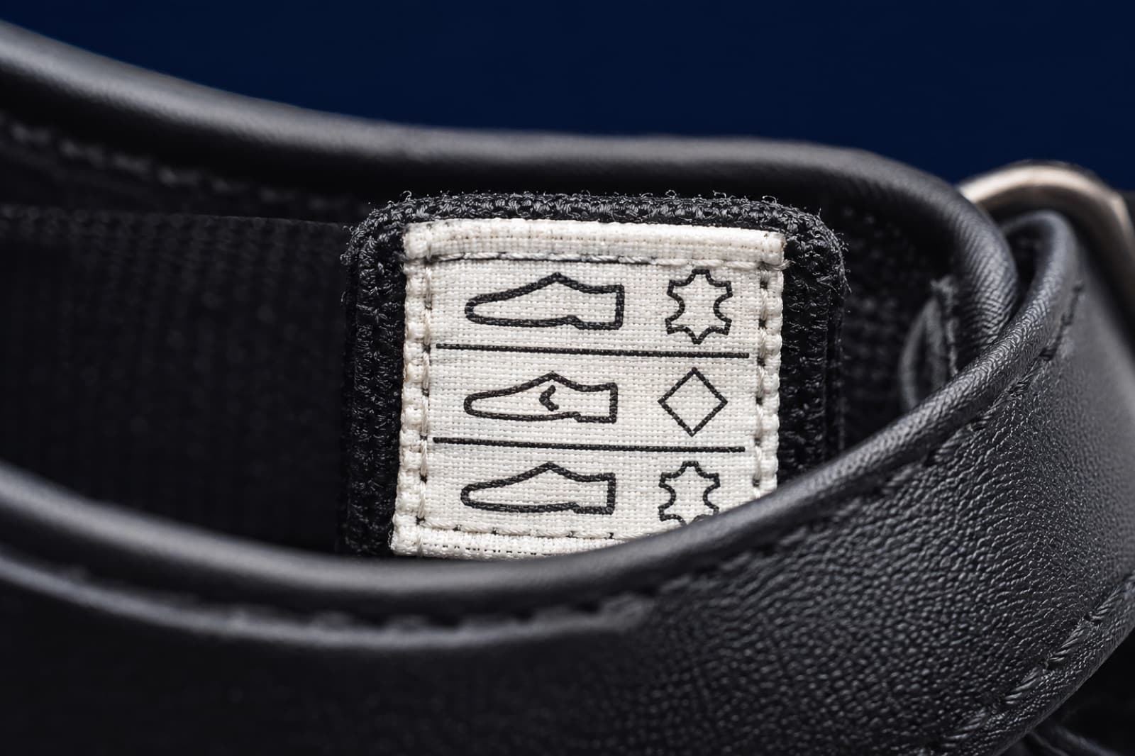The stitched material label inside the shoe showing three rows of pictogram symbols